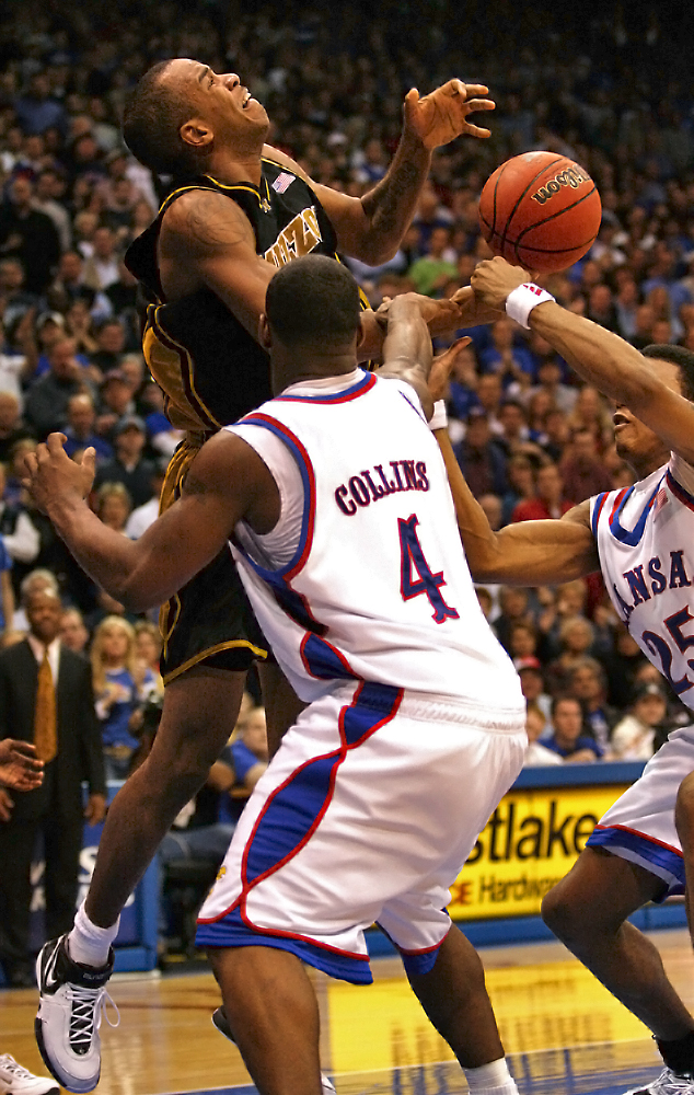 Missouri forward Leo Lyons tries to hold onto the ball as Kansas guards Sherron Collins and Brandon Rush grab at Lyons' forearm during the game's second half on Jan. 15, 2007, at Allen Fieldhouse. The Tigers attempted a failed three-point play in the game's final 11 seconds and lost 80-77 to the Jayhawks.